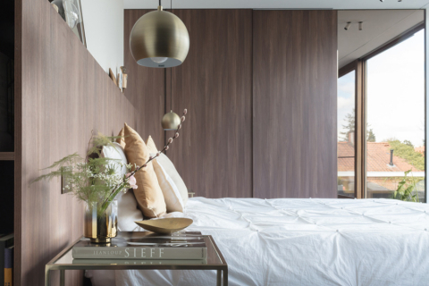 Bed in slaapkamer met goud en houten tinten